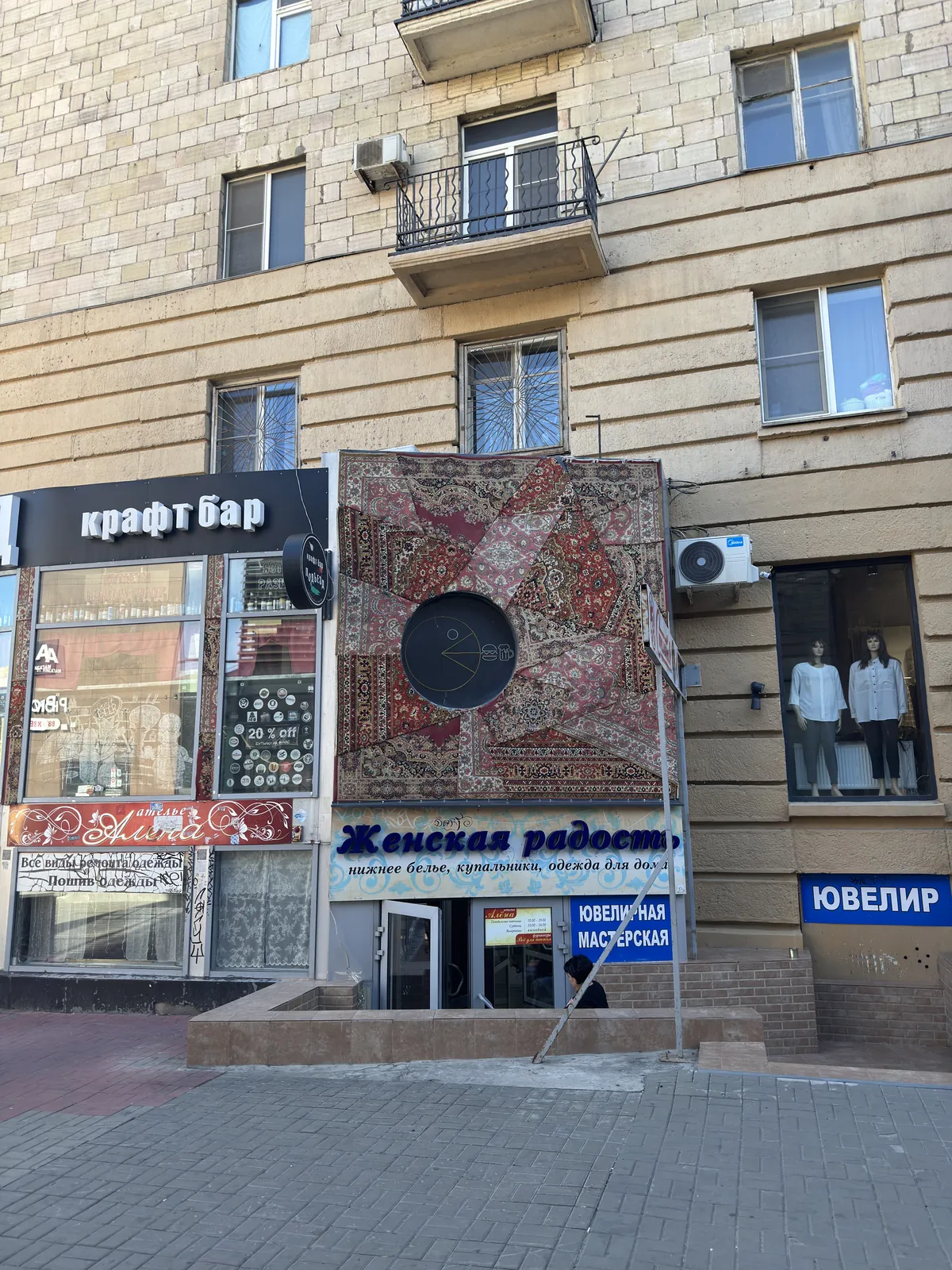 Ковёр на фасаде жилого дома над магазином женского белья и крафтовым баром